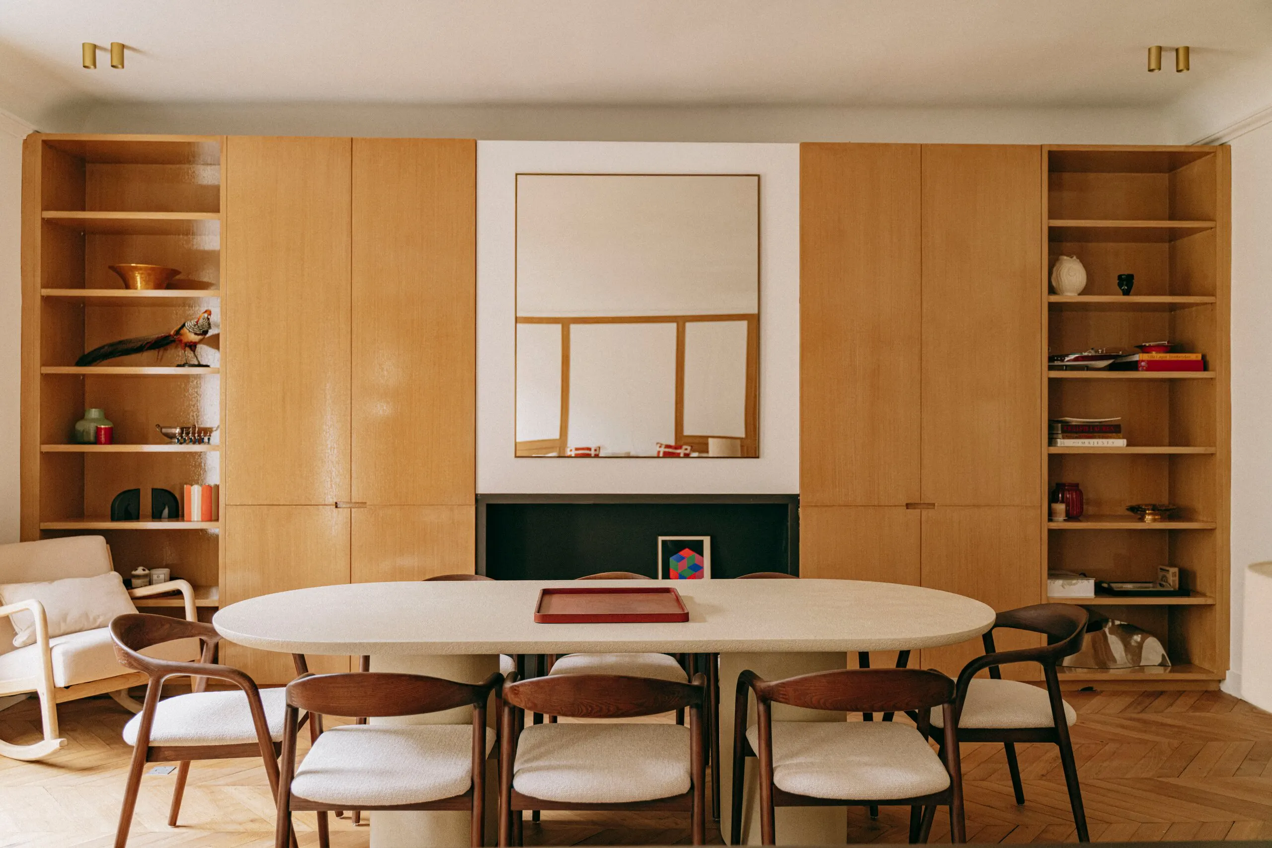 Salle à manger, table ovale entre deux bibliothèques en bois